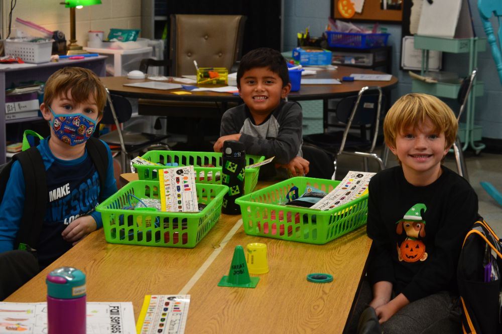 Three kindergarten students are working in the classroom